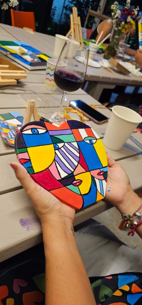 Manos sosteniendo una obra terminada de estilo pop, con colores planos y contorno negro
